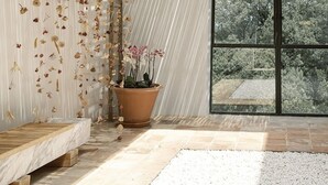 Un intérieur moderne avec un plafond en bois, une grande fenêtre et une plante en pot.