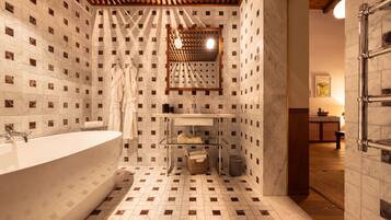 A modern bathroom with a freestanding bathtub, a vanity with a mirror, and a wooden ceiling.