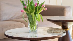 A modern living room with a round coffee table and a glass vase with flowers. - Luxury Apartment Matkovic (Split)