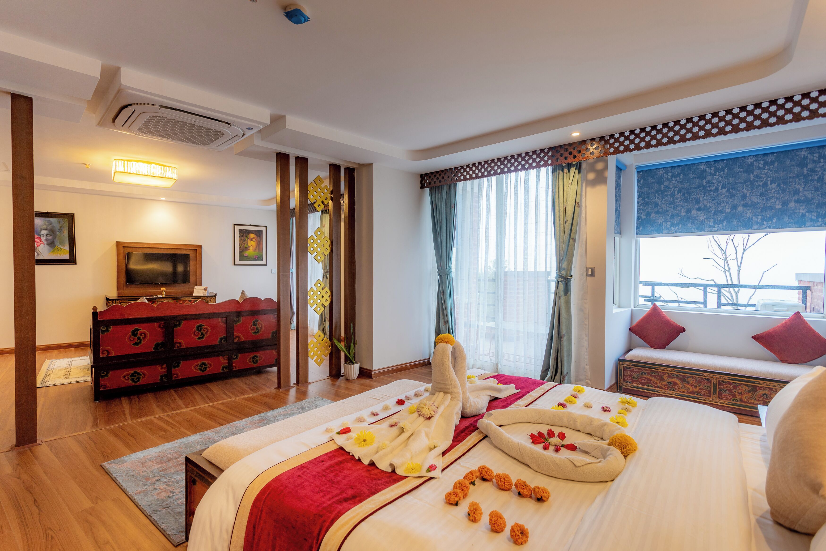 A hotel room with a bed, a TV, a dresser, and a window with a view.
