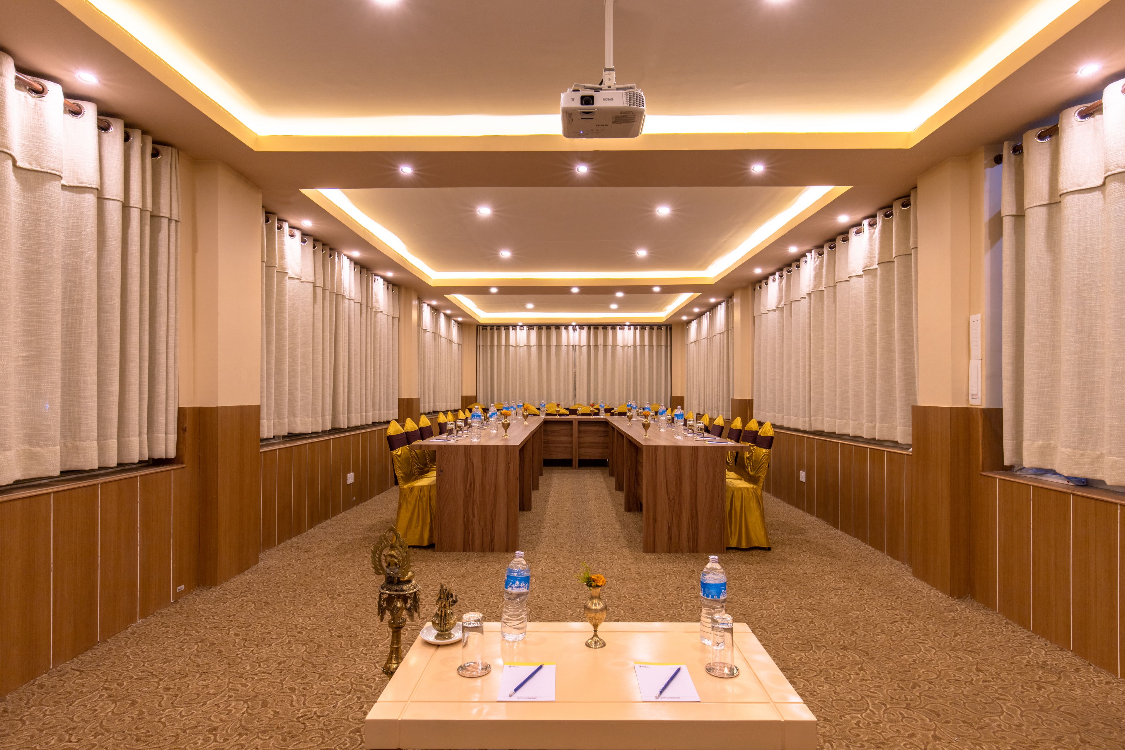 Une salle de conférence avec une longue table, des chaises et un projecteur.