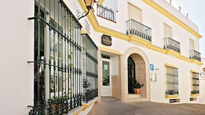 A building with a white facade, green wrought iron balcony railings, and a sign reading "La Posada". - Hostal La Posada de Conil (Conil de la Frontera)