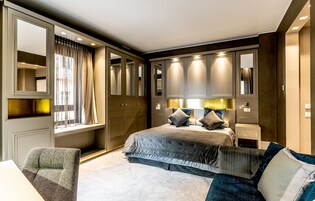 Un dormitorio moderno con una cama grande, armario empotrado y zona de estar.