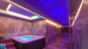 Une salle de bain moderne avec un jacuzzi, des murs en pierre et une verrière.
