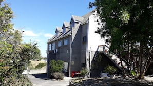 Un bâtiment moderne à deux étages, doté d’un toit en pente, d’antennes paraboliques et d’un petit balcon.