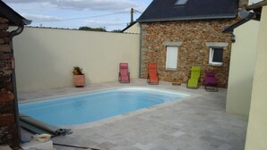A swimming pool with a stone wall and a staircase leading up to it. - Chambres d’hôtes les alouettes (Vair-sur-Loire)