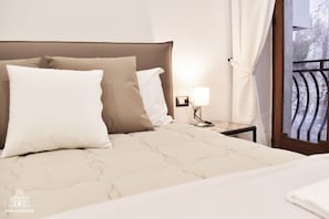 Deluxe Quadruple Room | Peralatan tempat tidur premium, meja, langsir/tirai gelap terus 