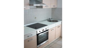 A modern kitchen with a built-in oven, a stovetop, and a sink.