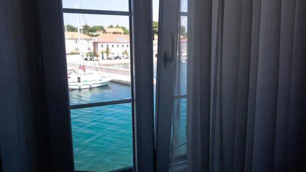A view from a window with a view of a marina and buildings in the distance.
