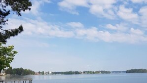 A waterfront deck with lounge chairs and a wooden pier. - Hotell Wettern (Karlsborg)