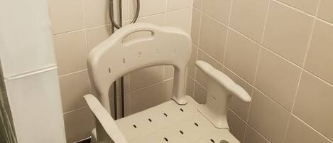 Ein Badezimmer mit Dusche, Toilette und einem Handtrockner.