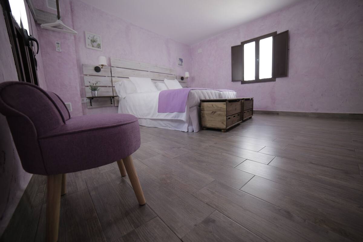 A room with a bed, a chest of drawers, and a chair.
