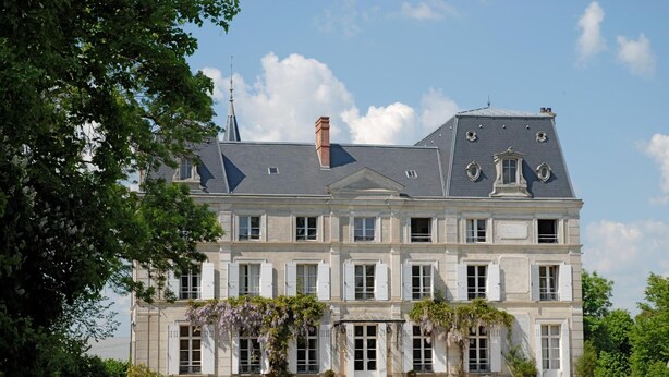 Ein großes, historisches Gebäude mit einer symmetrischen Fassade, zahlreichen Fenstern und einem markanten Haupteingang.