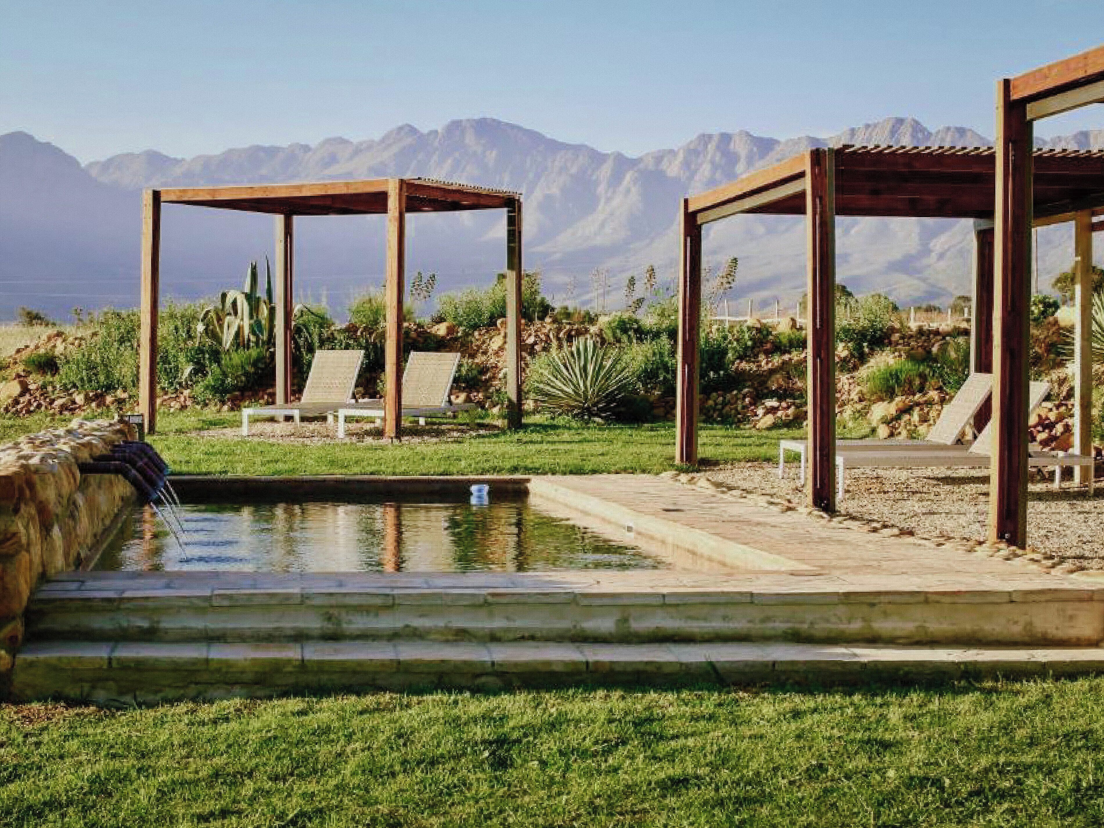Una piscina al aire libre, sombrillas, sillones reclinables de piscina