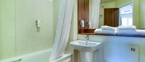 Ein Badezimmer mit Badewanne, Waschbecken und Spiegel.