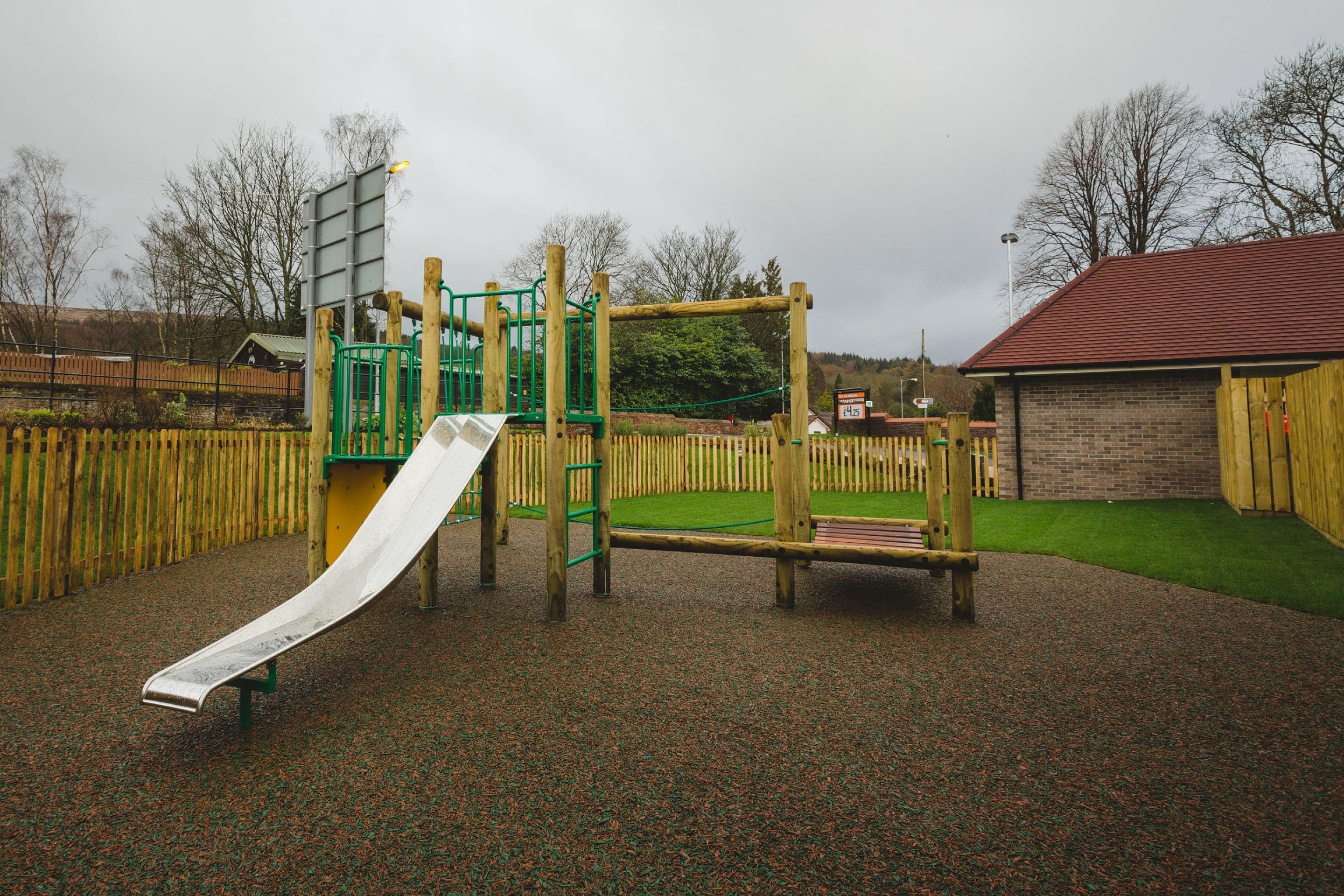 A playground with a slide, climbing structures, and a fenced area.
