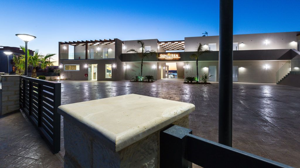 A modern hotel with a spacious outdoor area, a pool, and a restaurant named 'SunSea'.