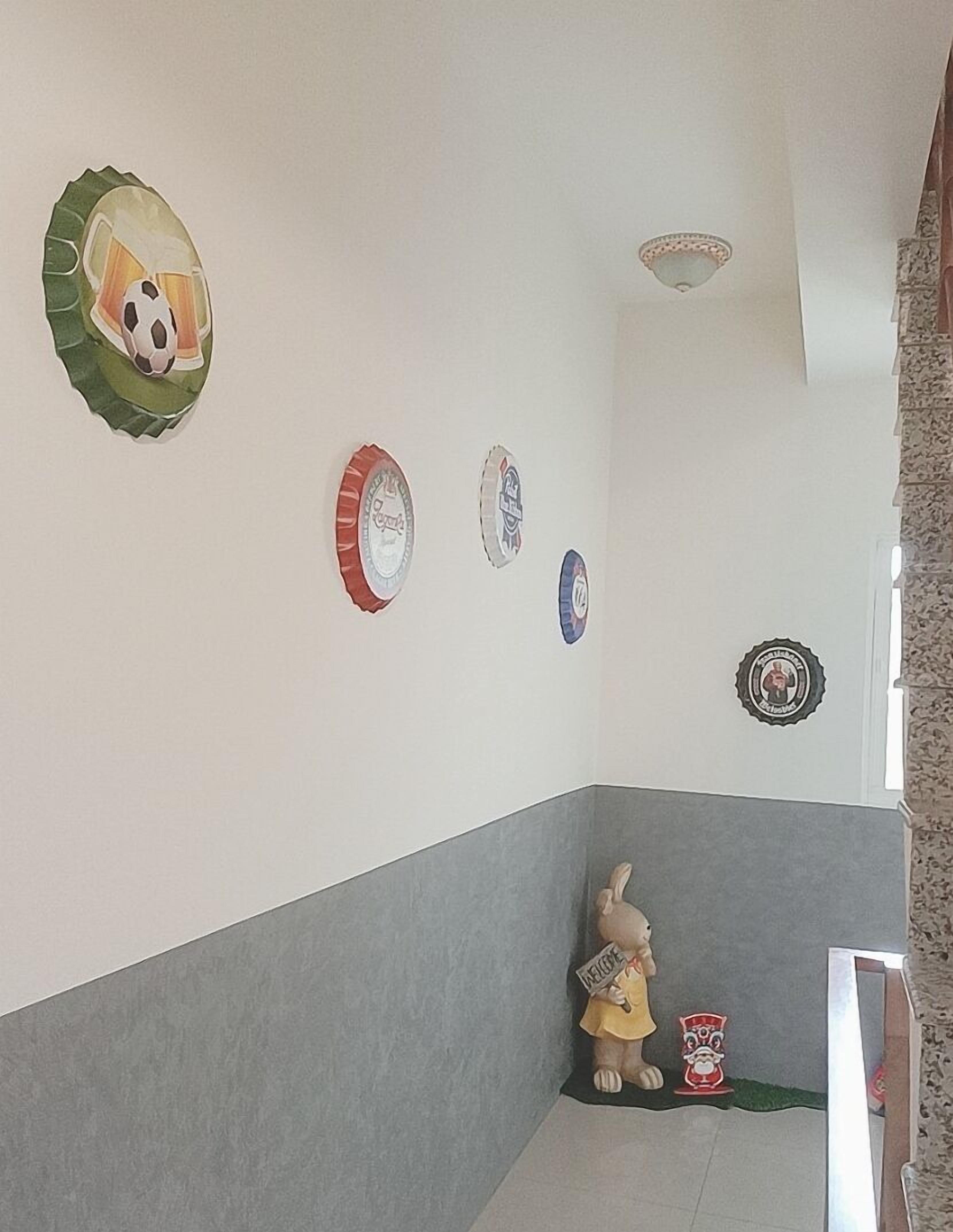 A hallway with a grey and white wall, a soccer ball decoration, and a welcome sign with a rabbit.