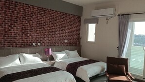 Une chambre d’hôtel avec deux lits, un mur en briques, un appareil de climatisation, une fenêtre avec des rideaux et un balcon.