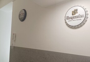 Una pared con dos adornos circulares, uno con un logotipo y texto, y otro con un diseño de tapón de botella de cerveza.
