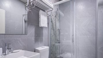 A modern bathroom with a shower, toilet, and sink.
