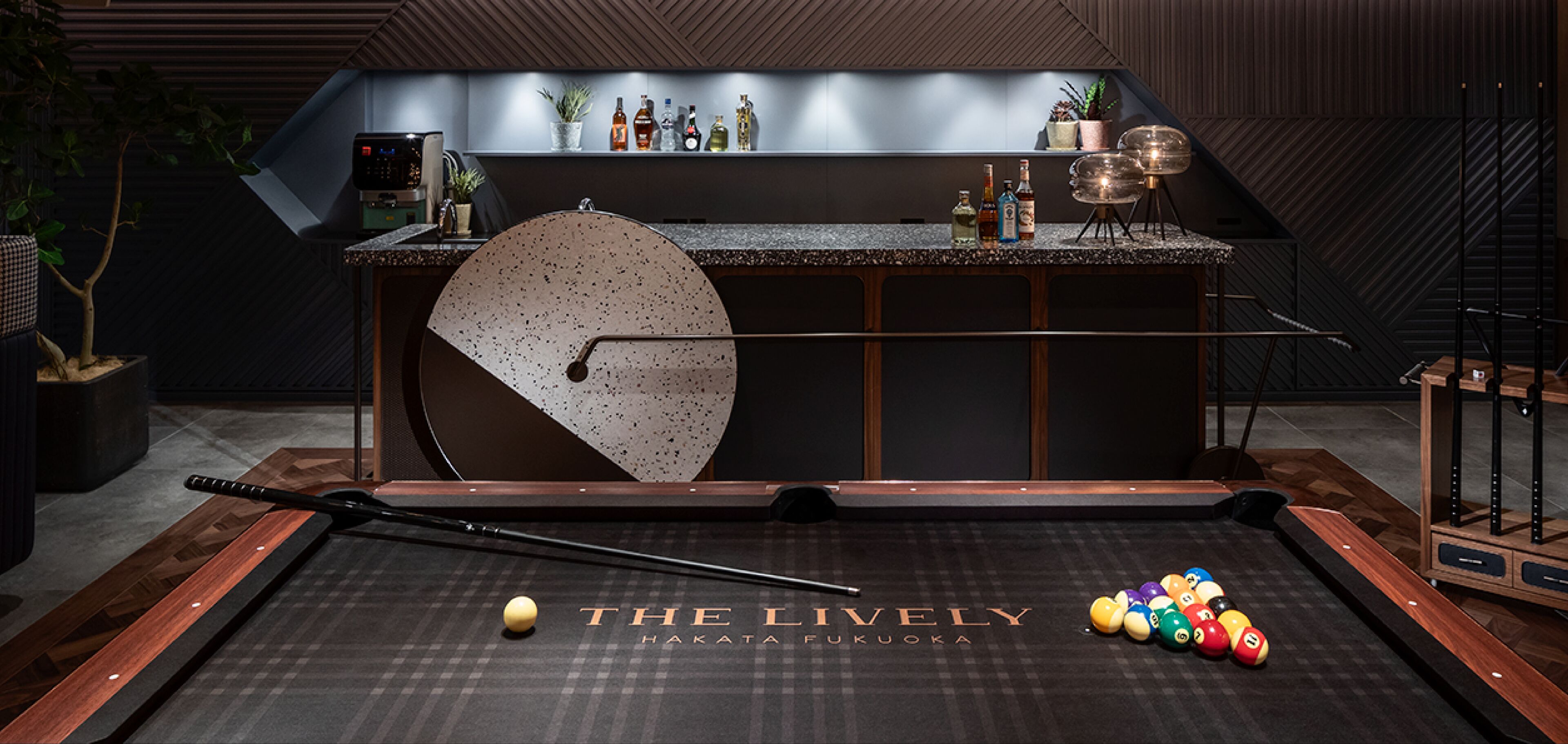 A billiards table with a pool cue and balls, a bar area with bottles, and a sign reading "THE LIVELY HAKATA FUKUOKA".