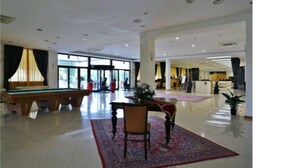 A spacious lobby with a pool table, a reception desk, and large windows allowing natural light. - Park Hotel Paradiso (Piazza Armerina)