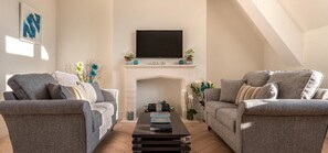 Tweepersoonskamer, voor 1 persoon | Woonruimte | Een flatscreentelevisie en een dvd-speler