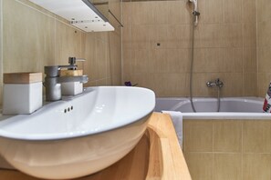 A modern bathroom with a large white sink, a bathtub, and a shower. - Old Town Square Royal Apartment (Prague)