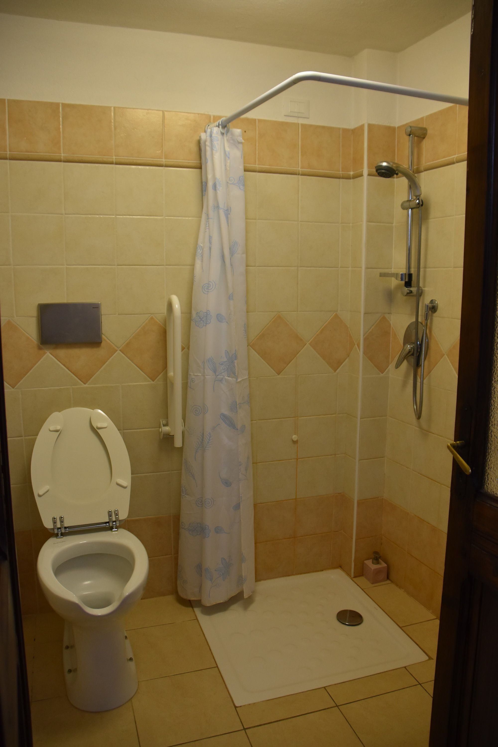 Une salle de bain équipée de toilettes, d’une douche et d’un sèche-mains.