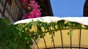 A building with a yellow facade, a white awning, and a metal railing. - Agriturismo corte di Gerardo (Tonco)