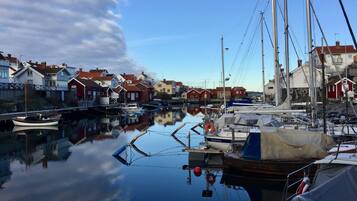 A marina with boats docked, surrounded by colorful houses.