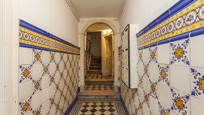 A hallway with patterned tiles and a checkered floor, leading to a staircase. - LxWay Apartments Praça da Alegria (Lisbon)