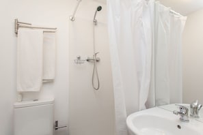 Een badkamer met toilet, wastafel, douche en een handdoekrek.