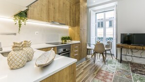 Une cuisine moderne avec des meubles en bois, un plan de travail blanc et un coin repas comprenant une table et des chaises.