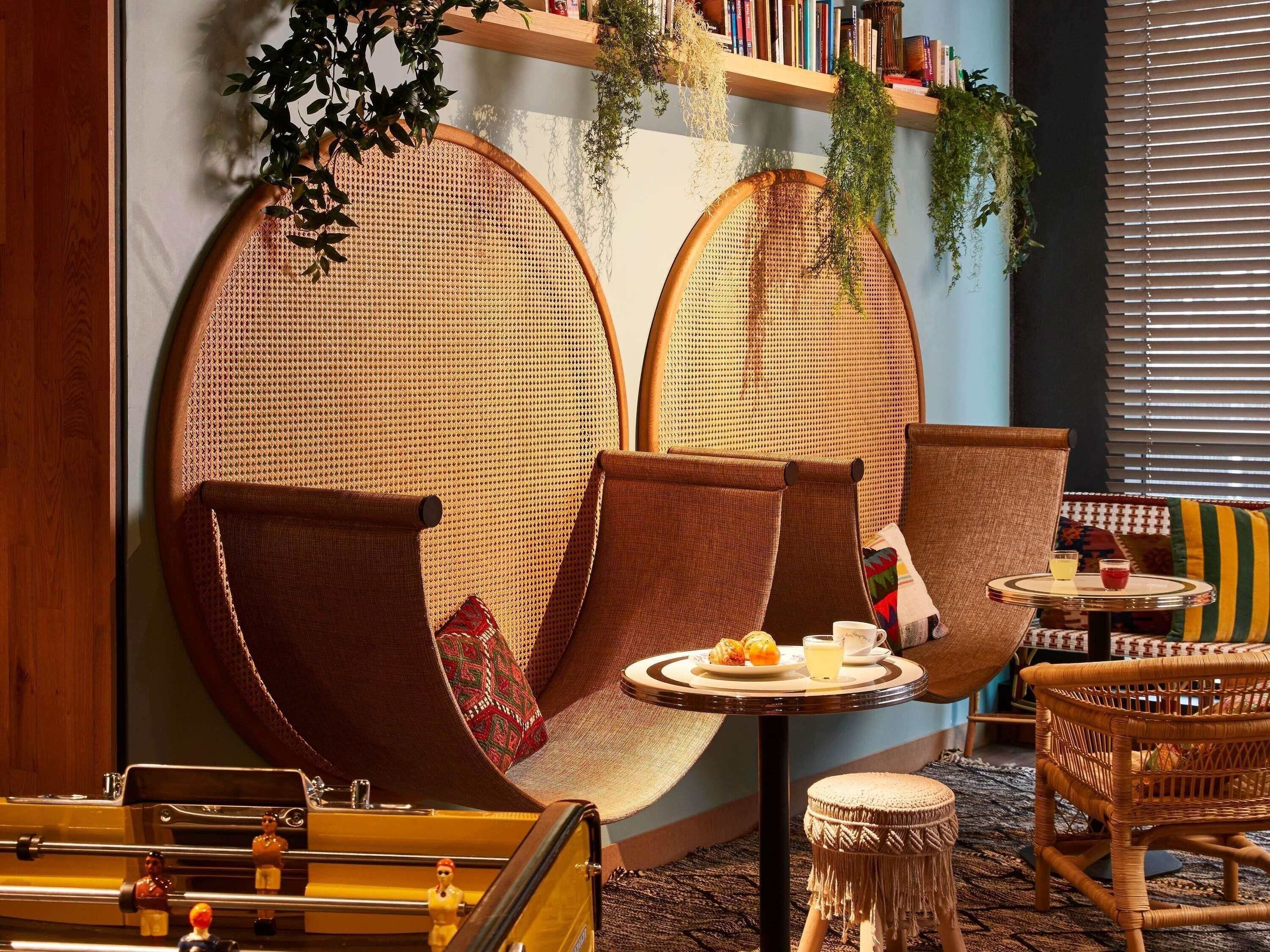 A cozy seating area with rattan chairs and a small round table with drinks and snacks.