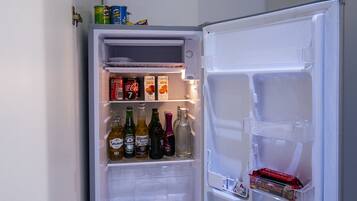 An open refrigerator stocked with beverages and snacks.