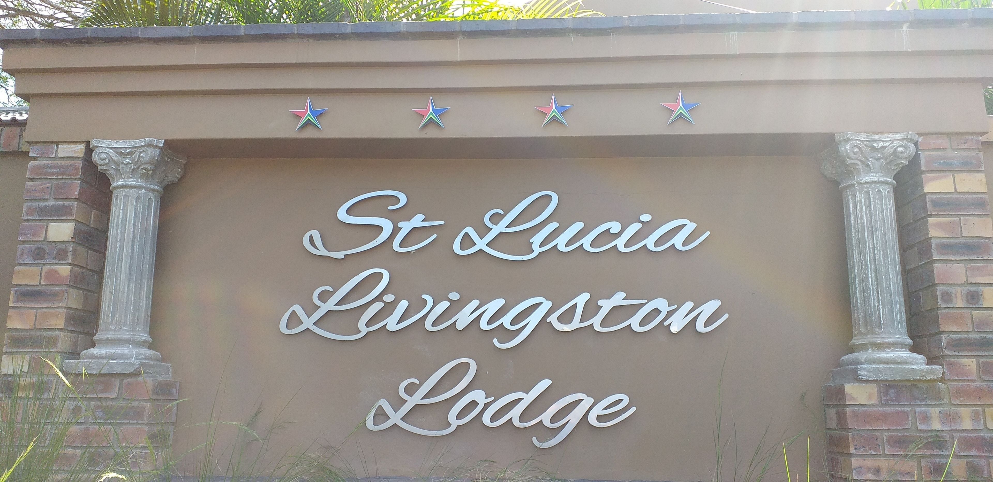 Un letrero para St. Lucia Livingston Lodge con estrellas decorativas encima del texto.