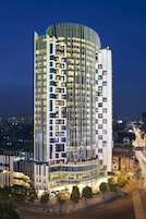 Un hotel moderno con fachada curva, varios balcones y un llamativo letrero de 'NOVOTEL'.