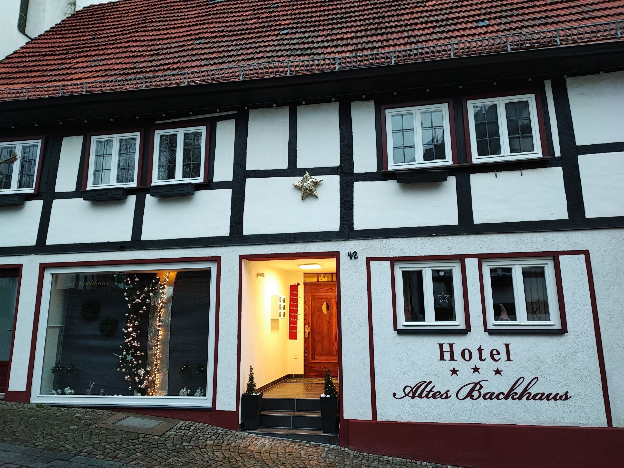 A traditional half-timbered building with a sign reading "Hotel Altes Backhaus".