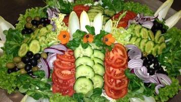 Ein Salat mit verschiedenen Gemüsesorten und Früchten, kreisförmig angeordnet.