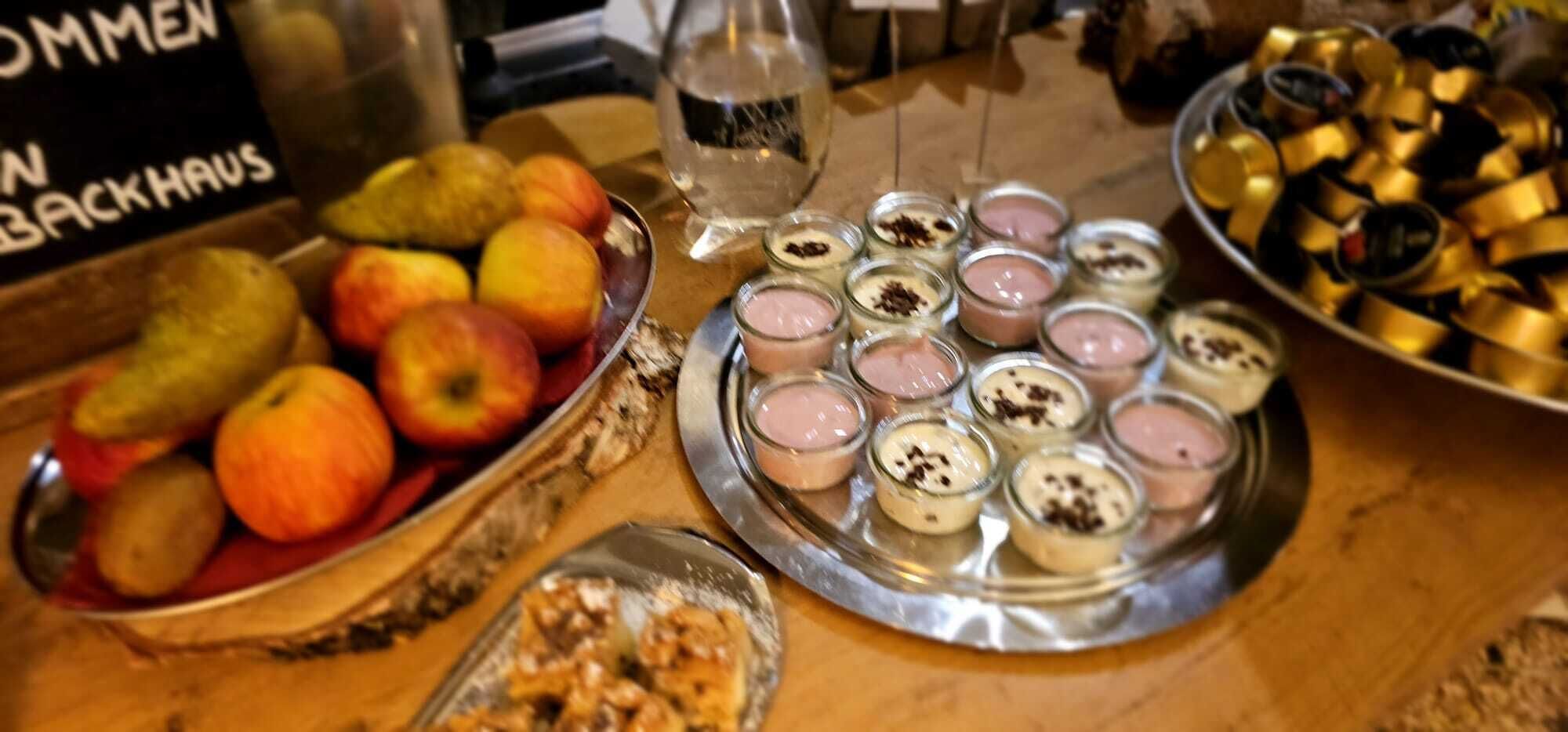Ein Tisch mit einer Auswahl an Speisen, darunter Obst und Desserts.