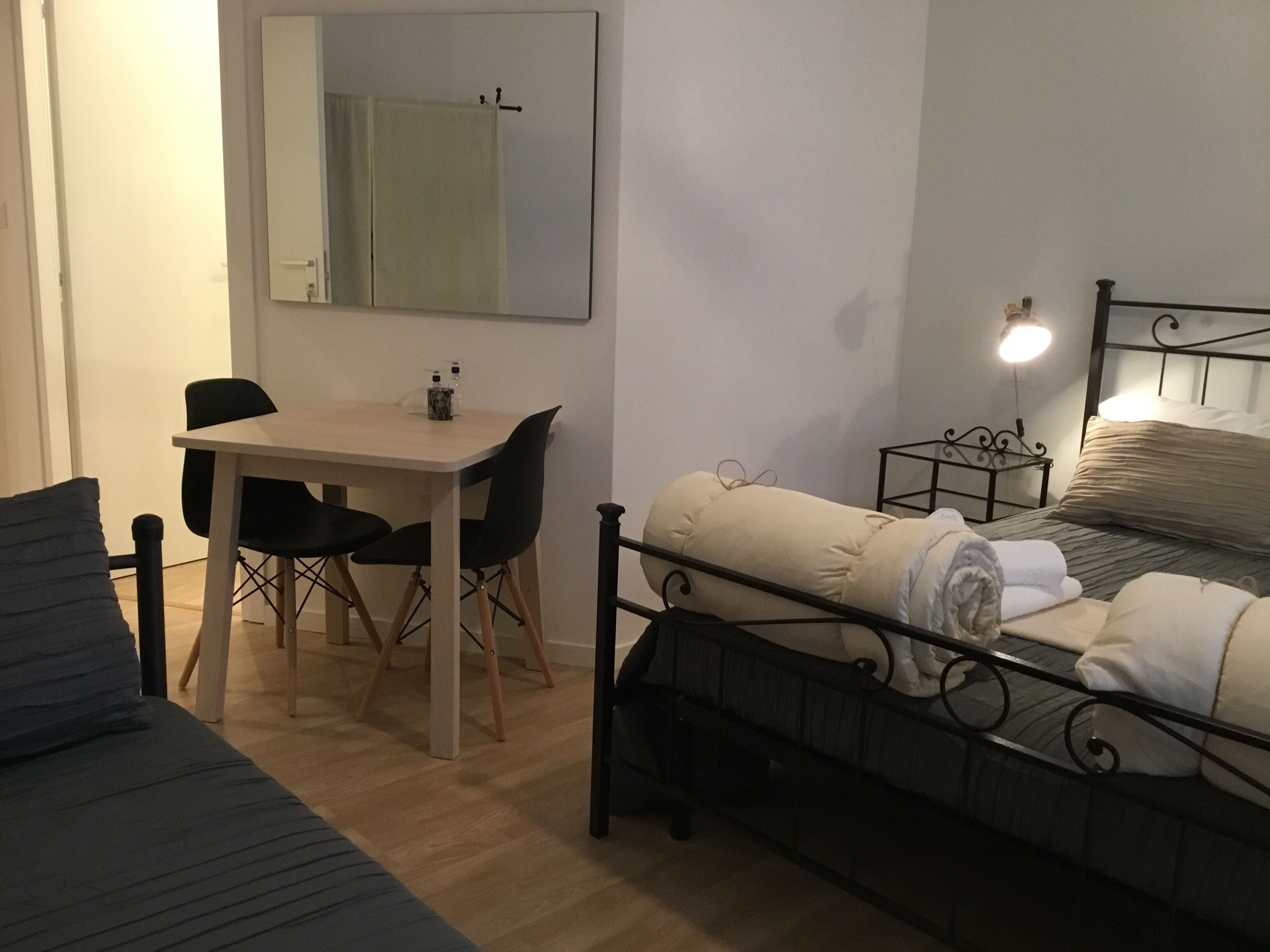 A compact bedroom with a bed, a small desk, and a chair.