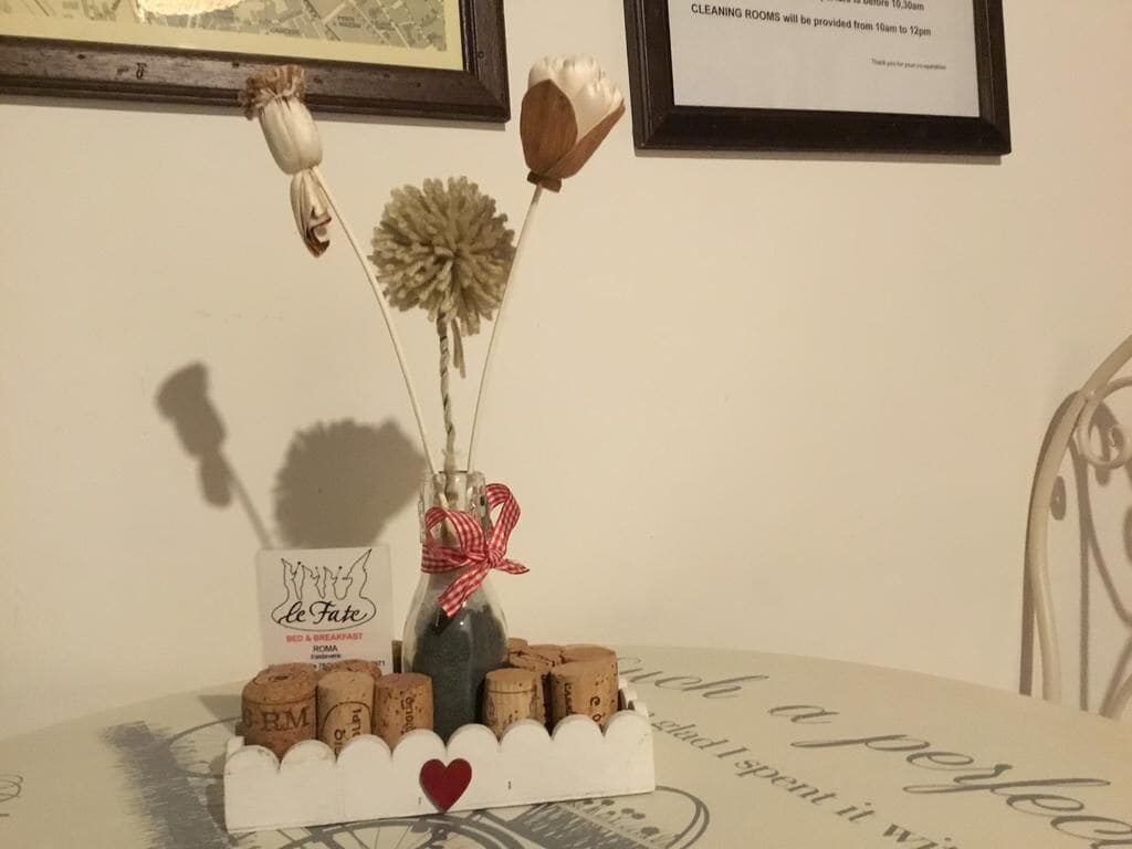 A table with a decorative arrangement of corks, a glass bottle, and a card with a heart symbol.