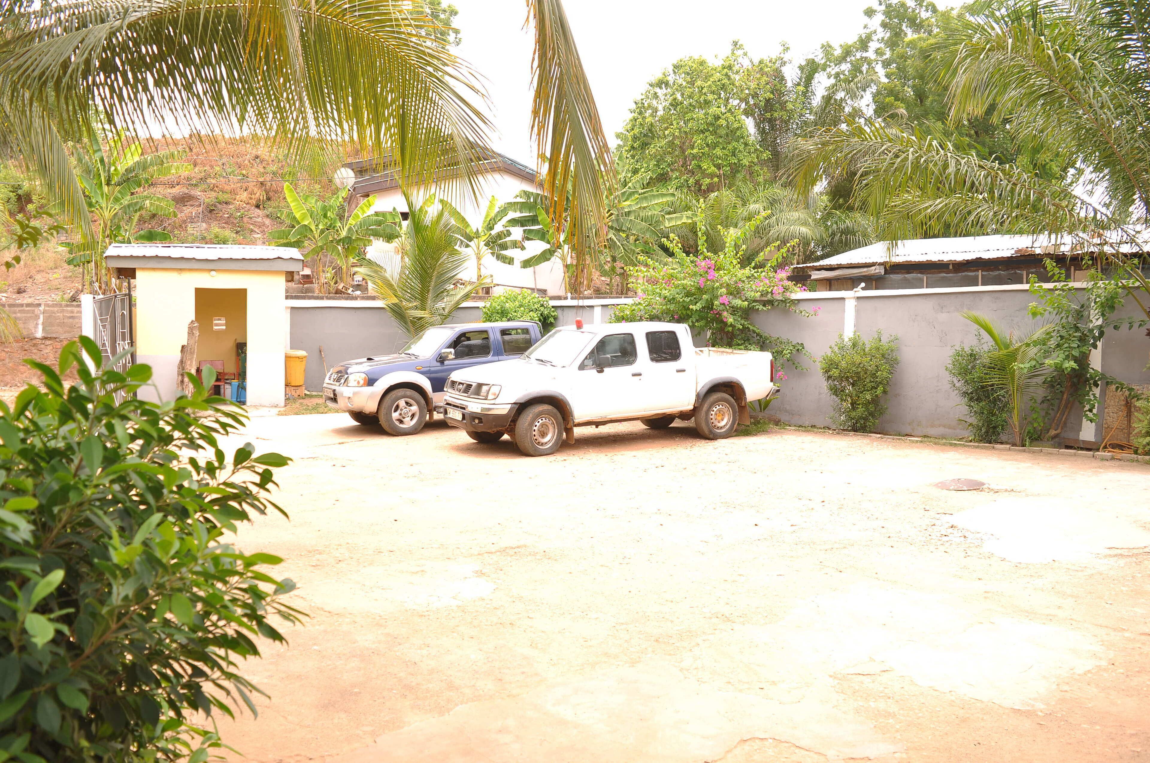 A white pickup truck parked in a driveway with a small shed and a house in the background.