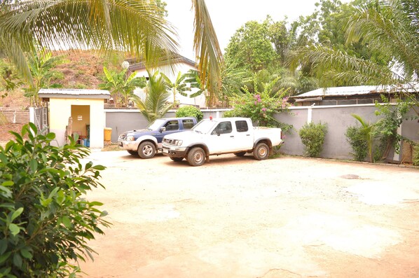 A white pickup truck parked in a driveway with a small shed and a house in the background.