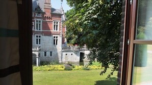 Blick auf ein historisches Gebäude mit einer Steinauffahrt und einem großen Rasen.
