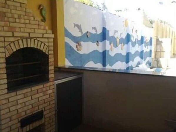 A brick fireplace with a decorative wall mural depicting sea creatures.