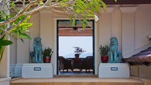 Vue d’un hall d’hôtel avec un espace salon, deux statues et une vue sur les montagnes.