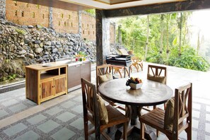 Enjoy meals al fresco at this inviting outdoor dining area with a round table and comfortable seating.